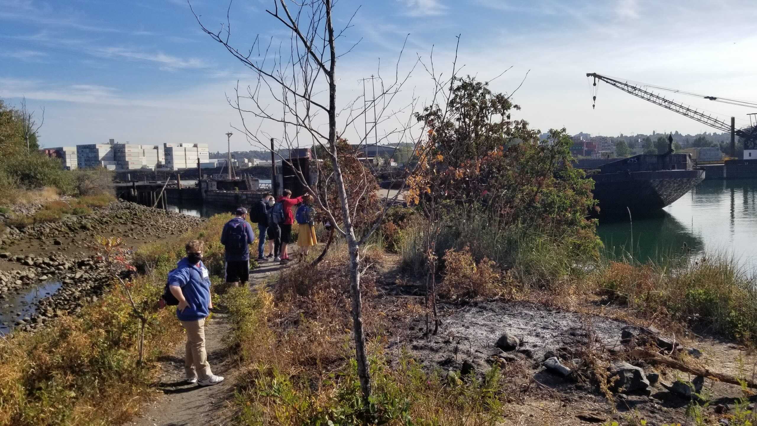 Students wearing masks on an excursion around the Northwest Maritime Center’s dock during the fall, ship is visible in the background