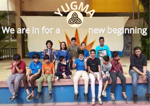 Students sitting at the edge of a stage, with “Yugma: We are in for a new beginning” written above them.
