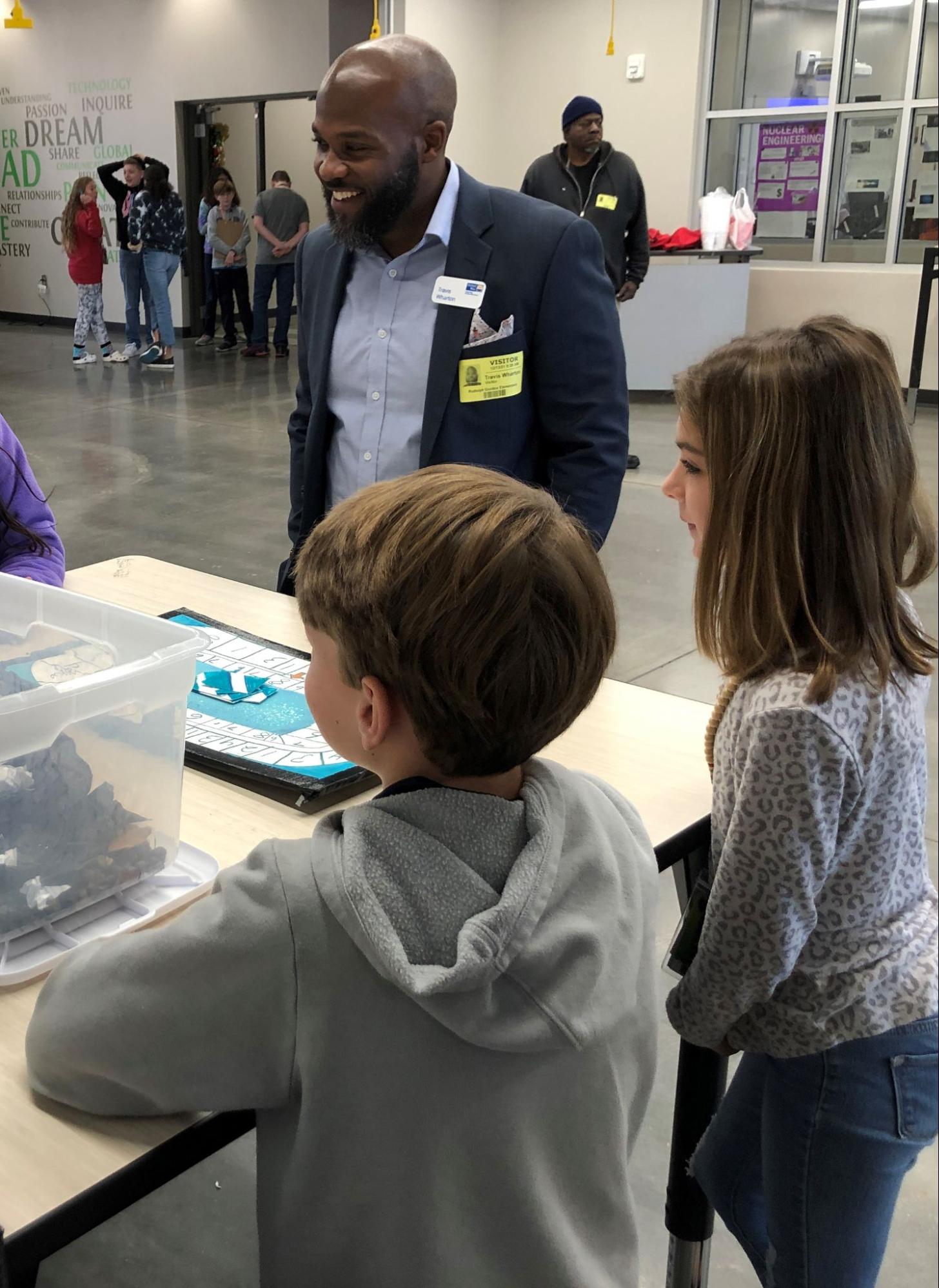 Students presenting their game to the vice president of United Way Greenville.