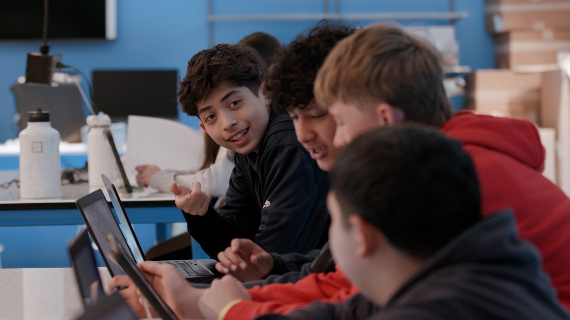 middle school boys looking at laptops