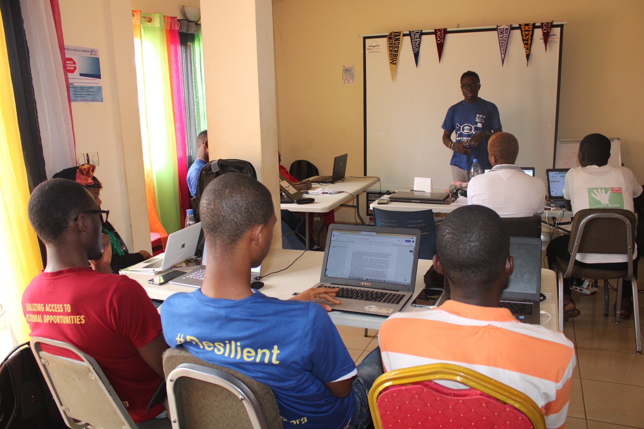 Kinlo speaks in front of a group of people in a conference room. 