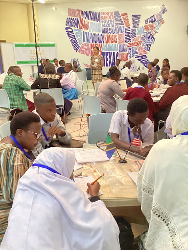 Students groups work together at desks in the American Corner space in Mwanza. 