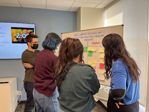 An image of four world history teachers standing in front of a white board with multi colored sticky notes