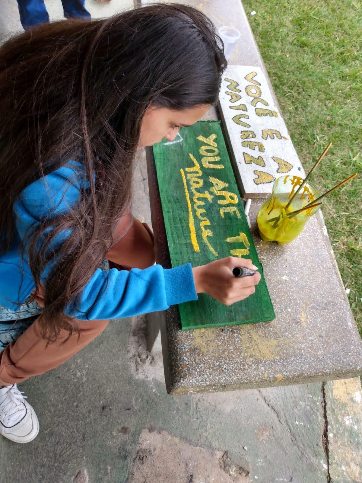 A student paints a sign. 