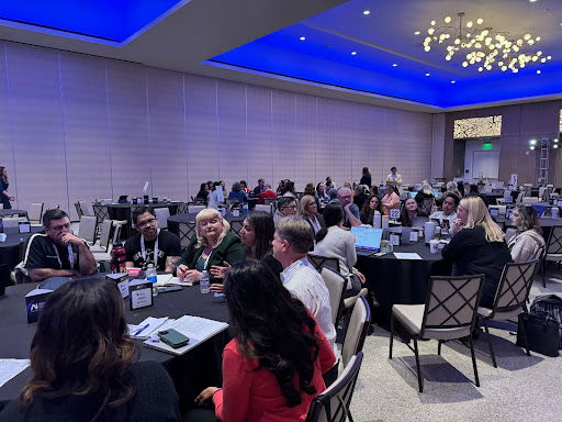 An image of fourty educators and leaders having roundtable discussions at the K12 AI Deeper Learning Summit.