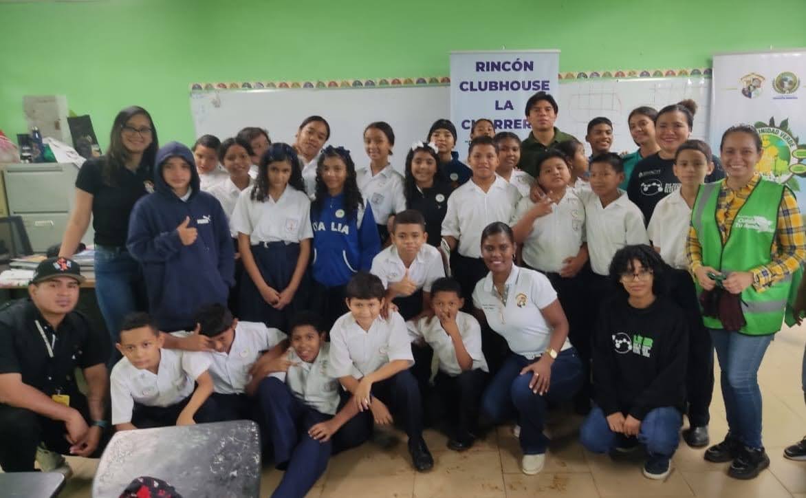 A group of students smiling for the camera in front of a Rincón Clubhouse banner.